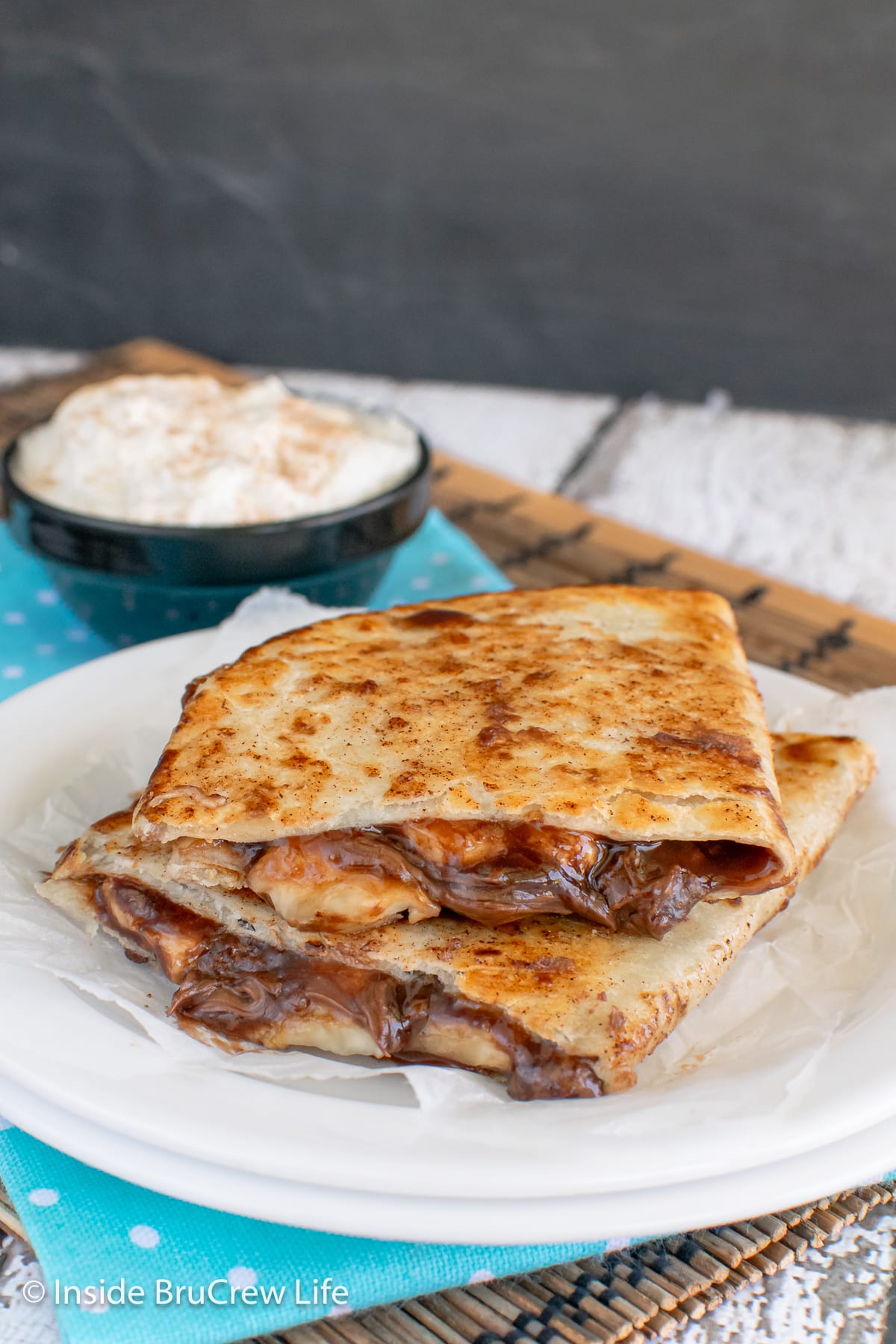 Two pan fried dessert quesadillas on a white plate.