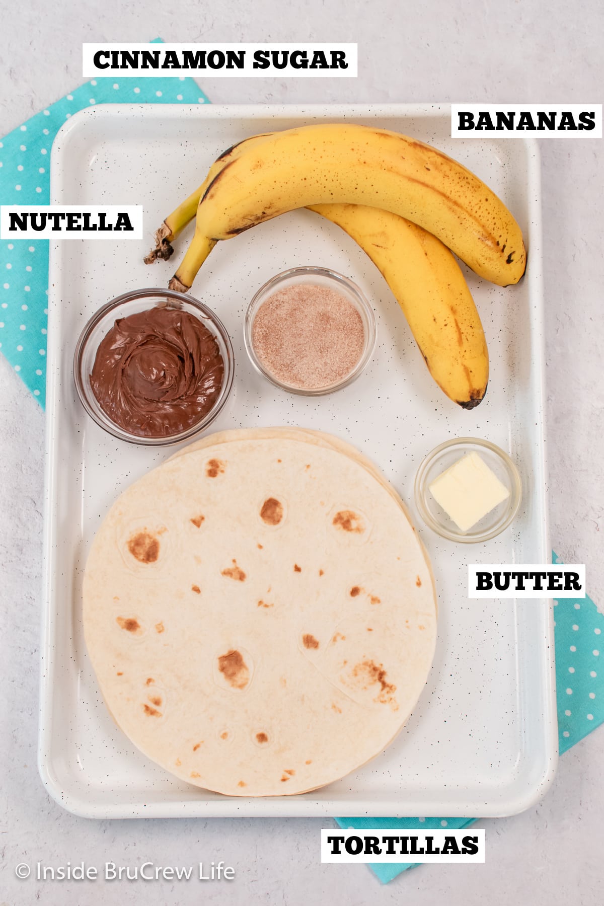 Ingredients needed to make dessert tortillas on a white pan.
