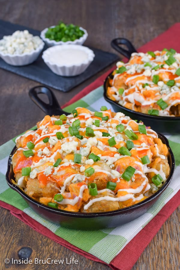 A cast iron skillet with tater tot buffalo nachos.