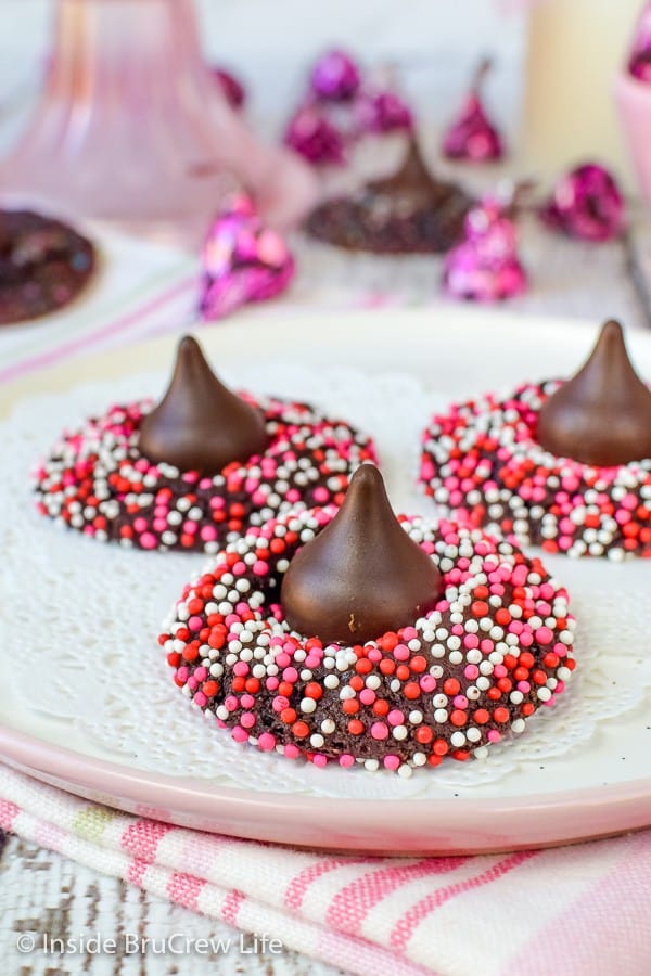Chocolate cookies with red, white, and pink sprinkles with a Hershey kiss on top.