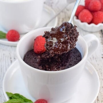 A white mug with chocolate lava cake in it.