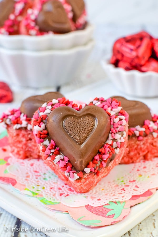 Pink rice krispie treats in the shape of a heart with candy on them.