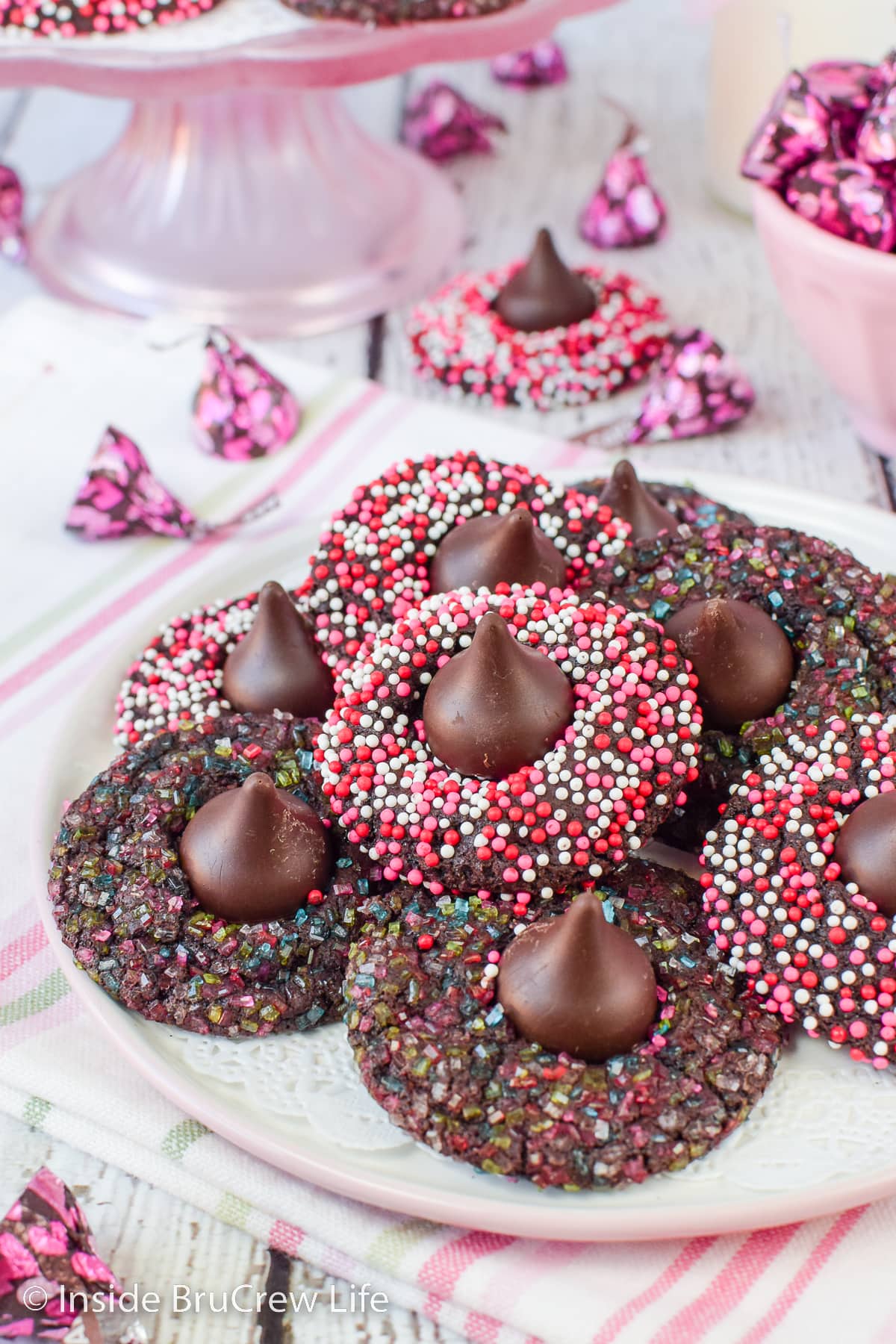 A stack of chocolate kiss cookies on a white plate.