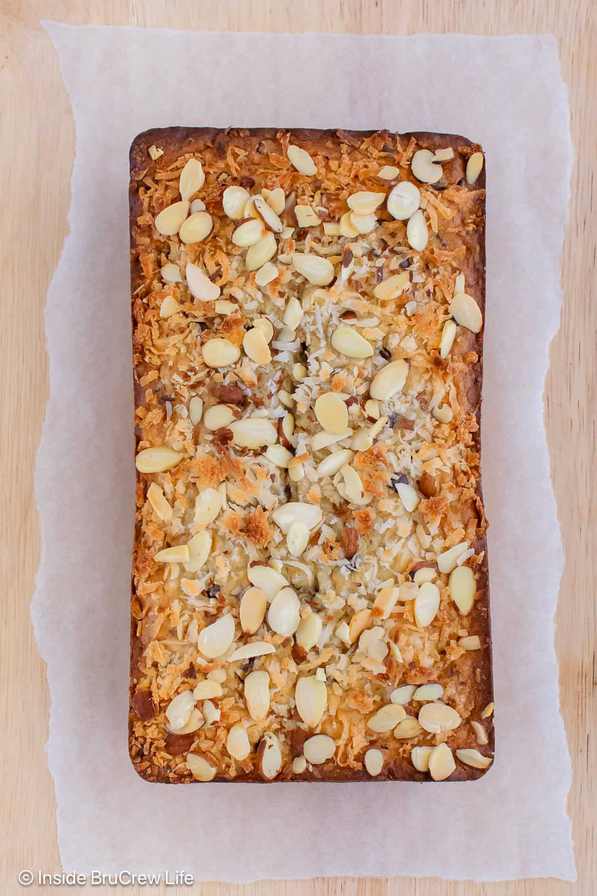 An overhead shot of a loaf of almond joy banana bread on a cutting board.