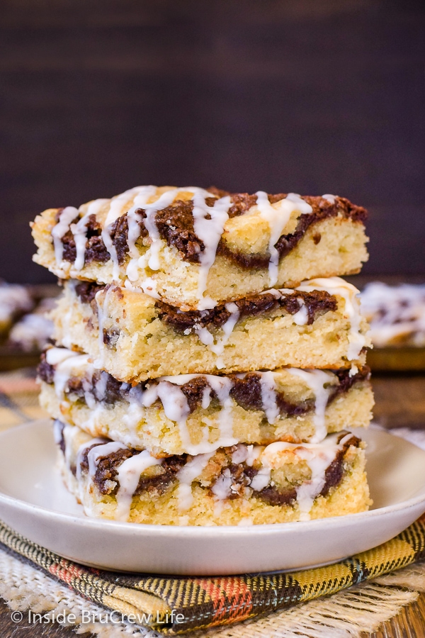 Stack of four banana nutella snack cake squares on a cream plate