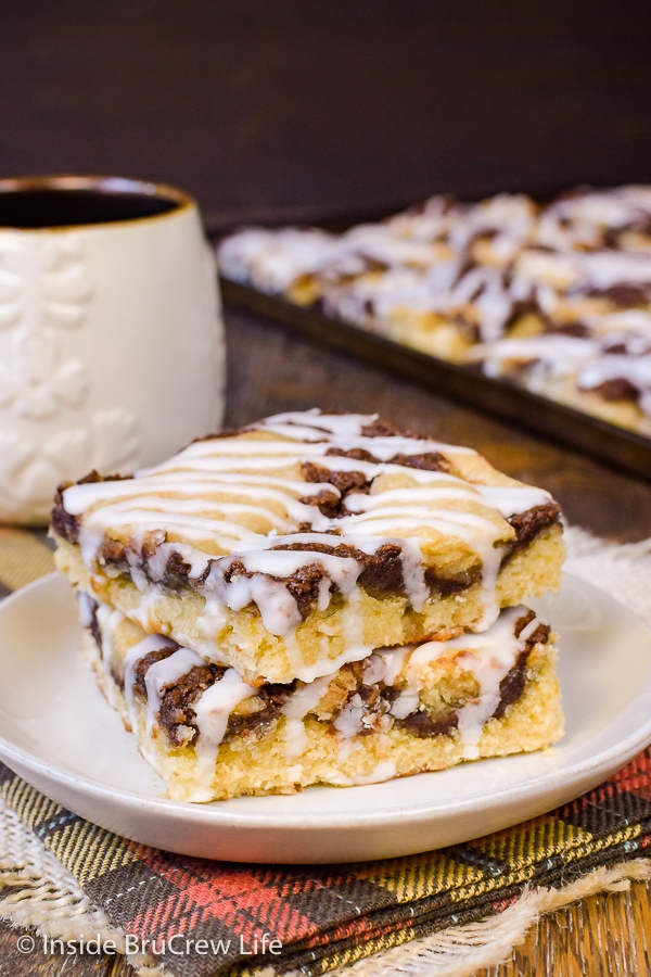 A cream plate with two squares of banana nutella snack cake stacked on it