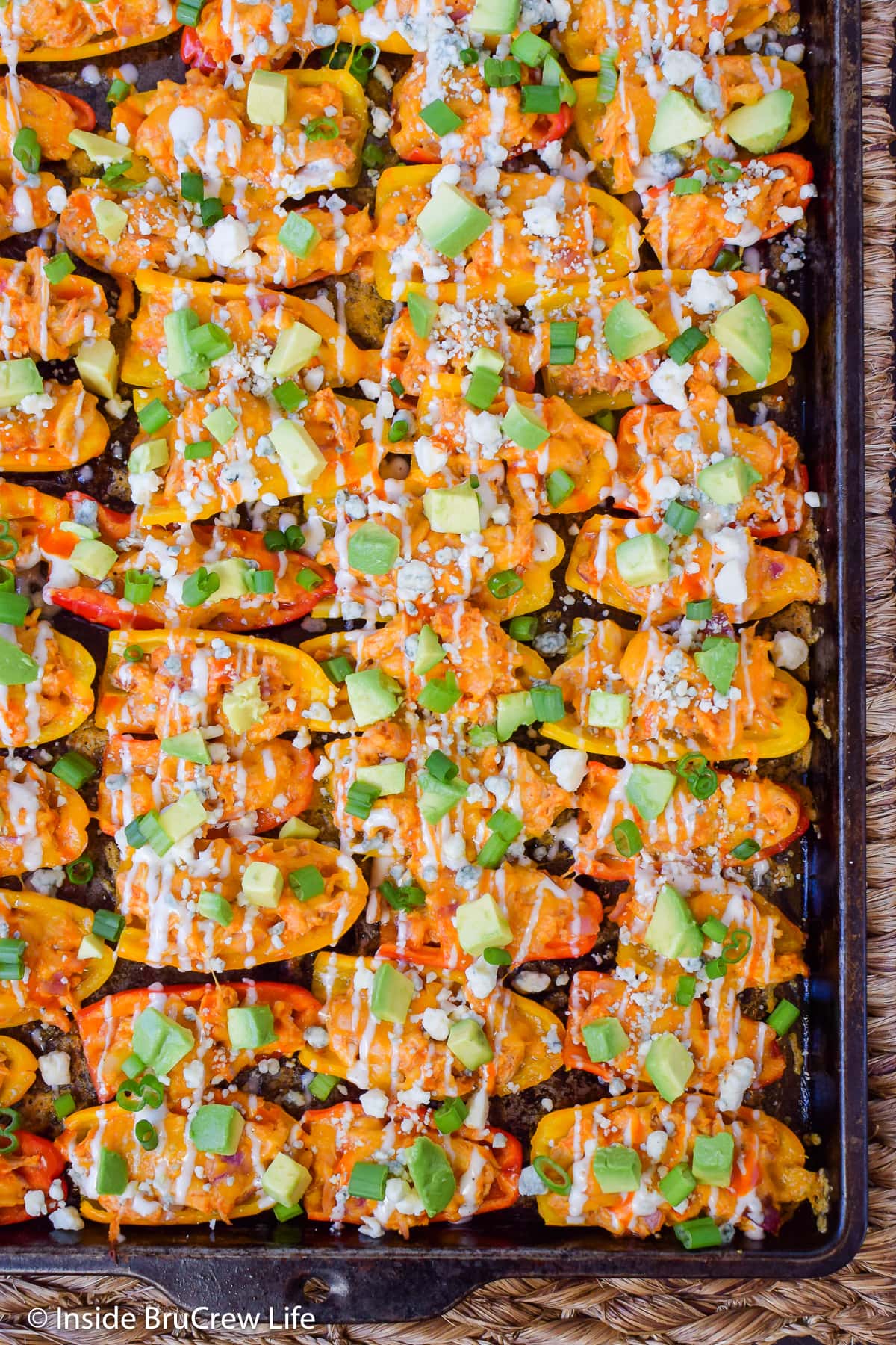 A sheet pan of peppers filled with chicken and cheese.
