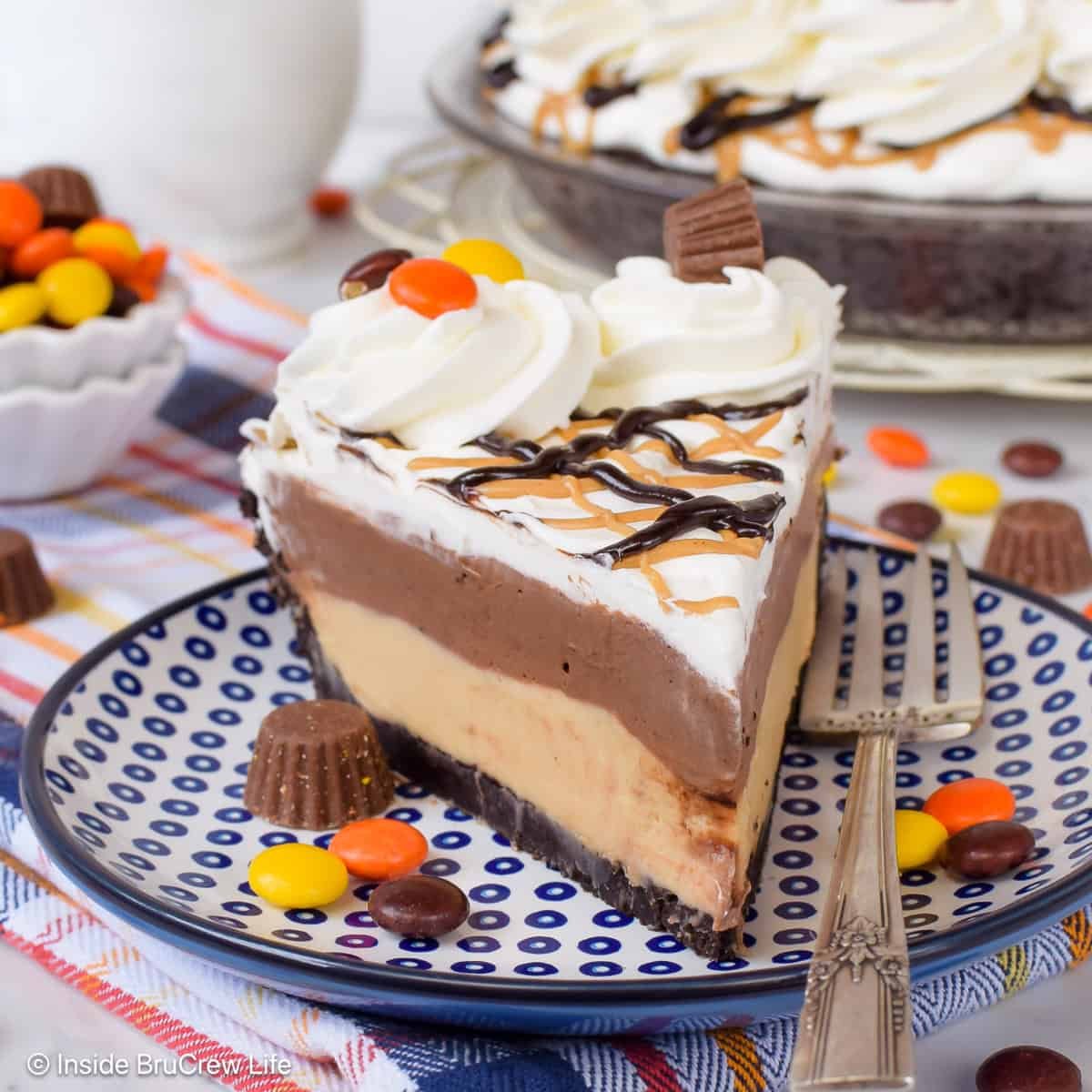 A slice of chocolate peanut butter pie with Reese' candies on top.