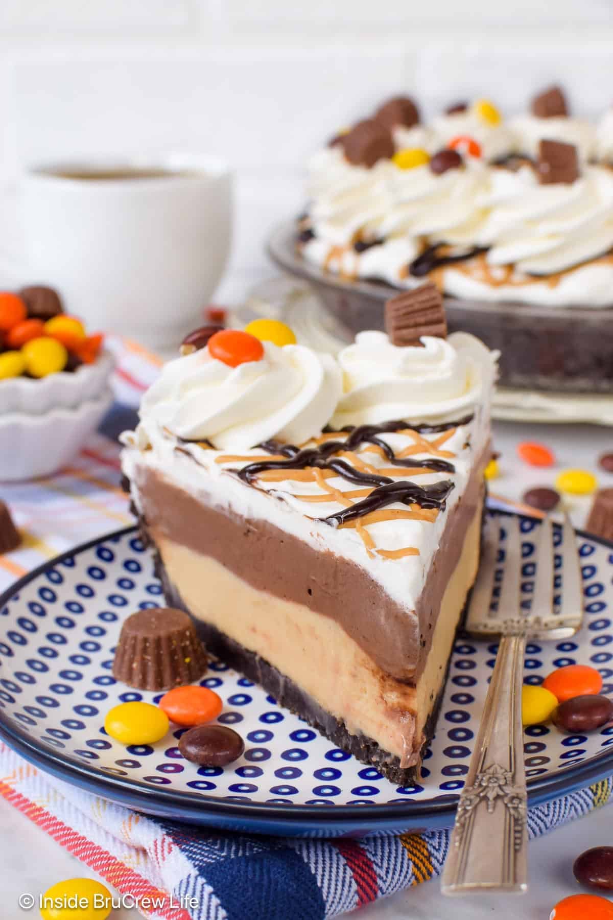 A slice of Reese's topped chocolate peanut butter pie on a plate.