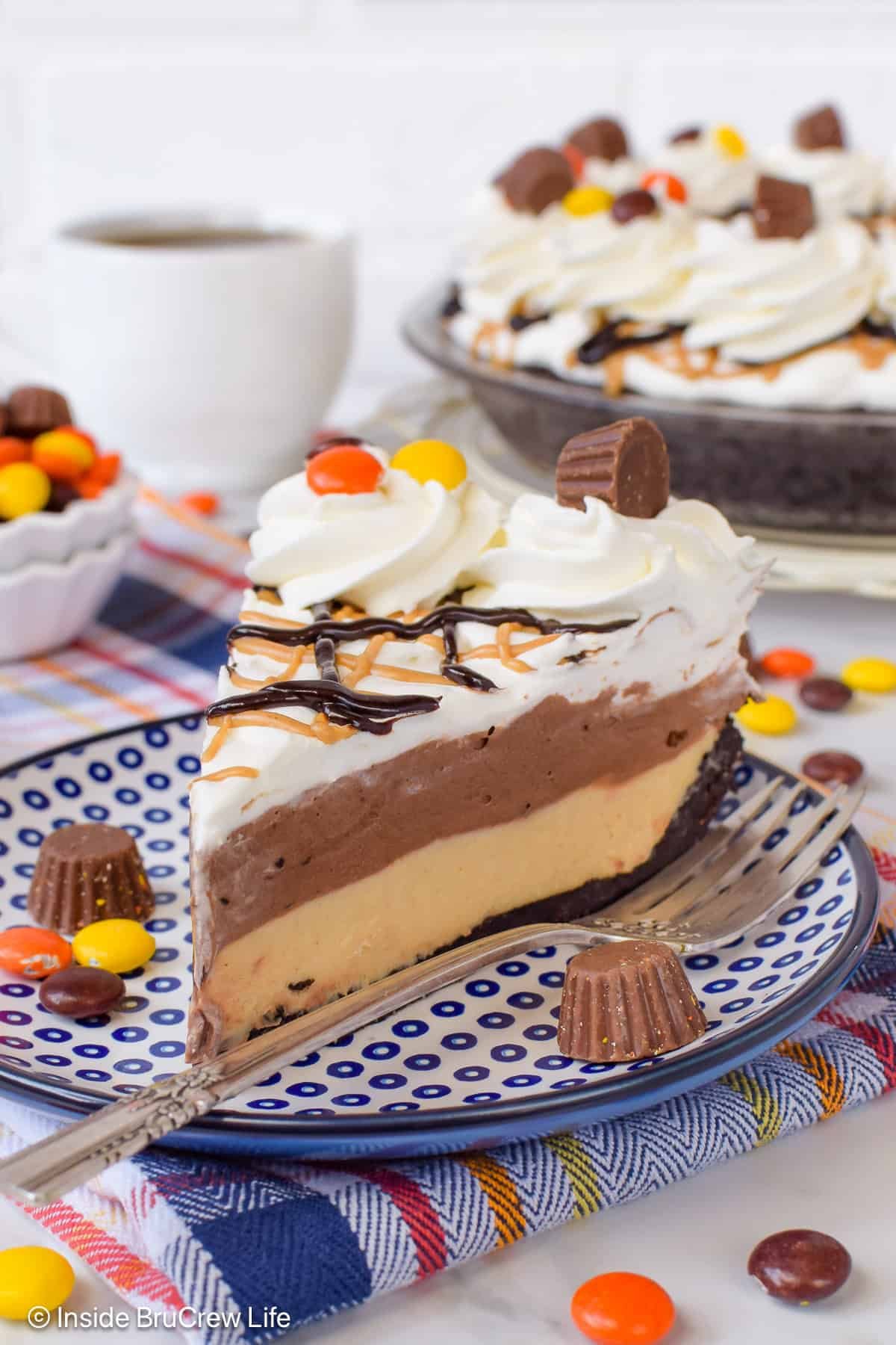 A layered peanut butter and chocolate pie on a plate.