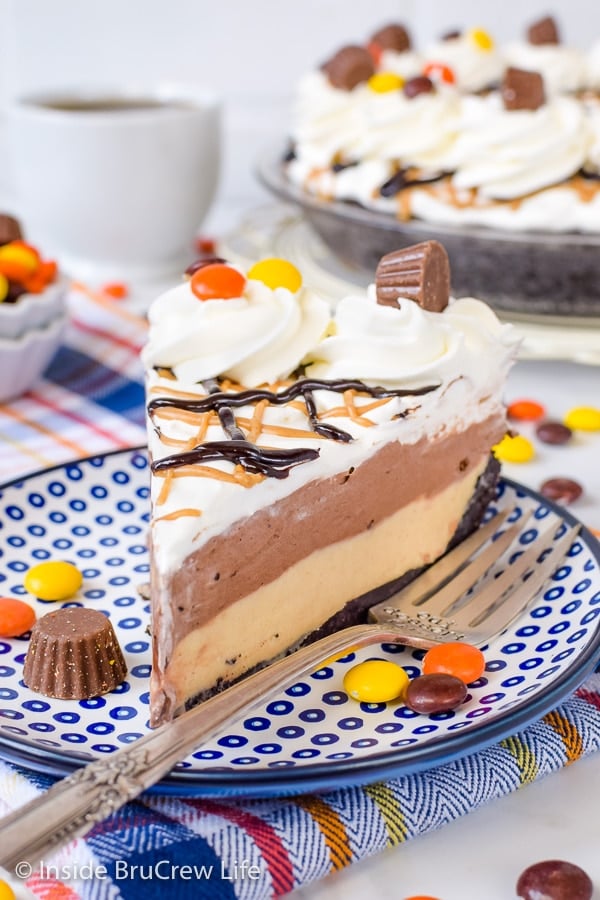 A slice of chocolate peanut butter pie topped with Cool Whip and Reese's candies