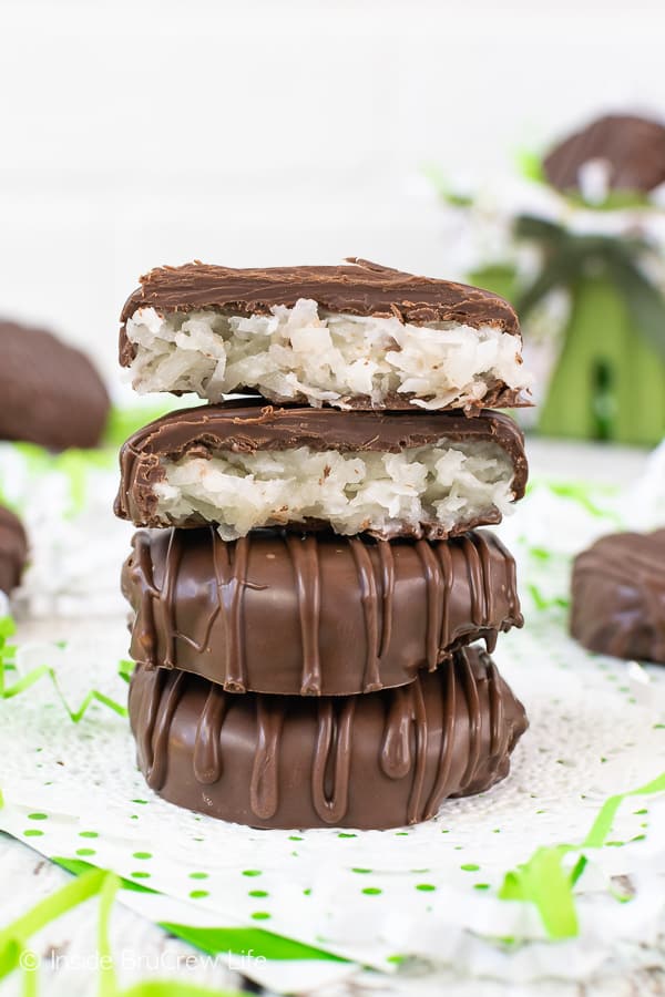 3 chocolate covered coconut patties stacked on top of each other with the top patty broken open to show coconut.