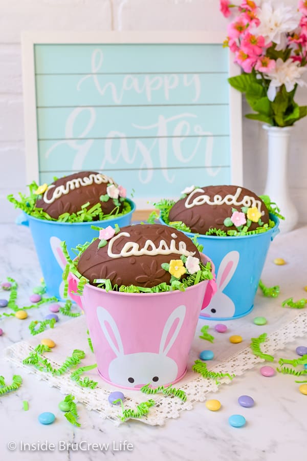 Three little Easter buckets with green grass, candies, and a giant homemade Reese's egg on top.