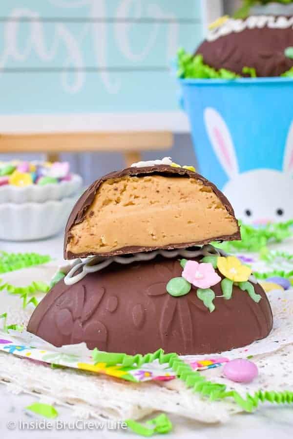 A Reese's egg decorated with candies and a name with a half of another peanut butter egg stacked on top.