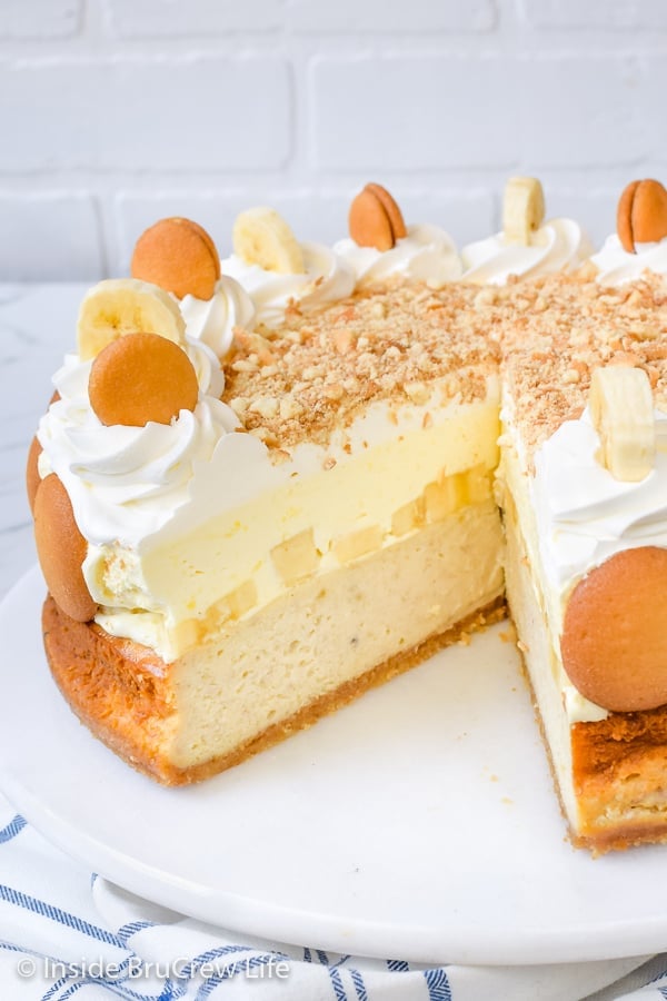 A white cake plate with banana cheesecake on it showing the inside of the fluffy pudding layer.