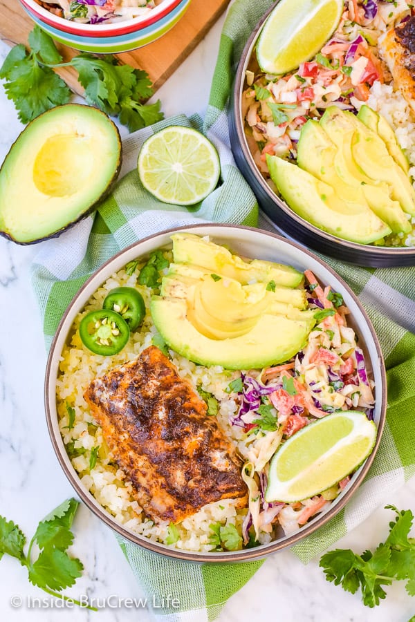 Overhead picture of two bowls on a white board filled with low carb fish tacos.