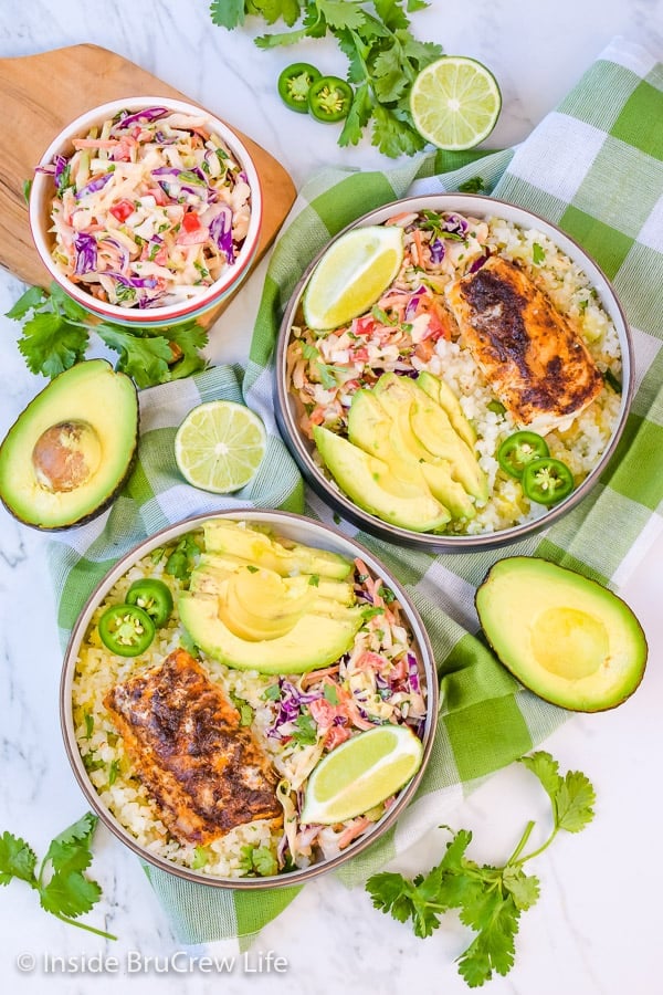Overhead picture of two bowls filled with fish tacos, cauliflower rice, and coleslaw.