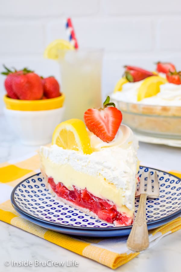 A blue and white plate with a slice of lemon cream strawberry pie on it.