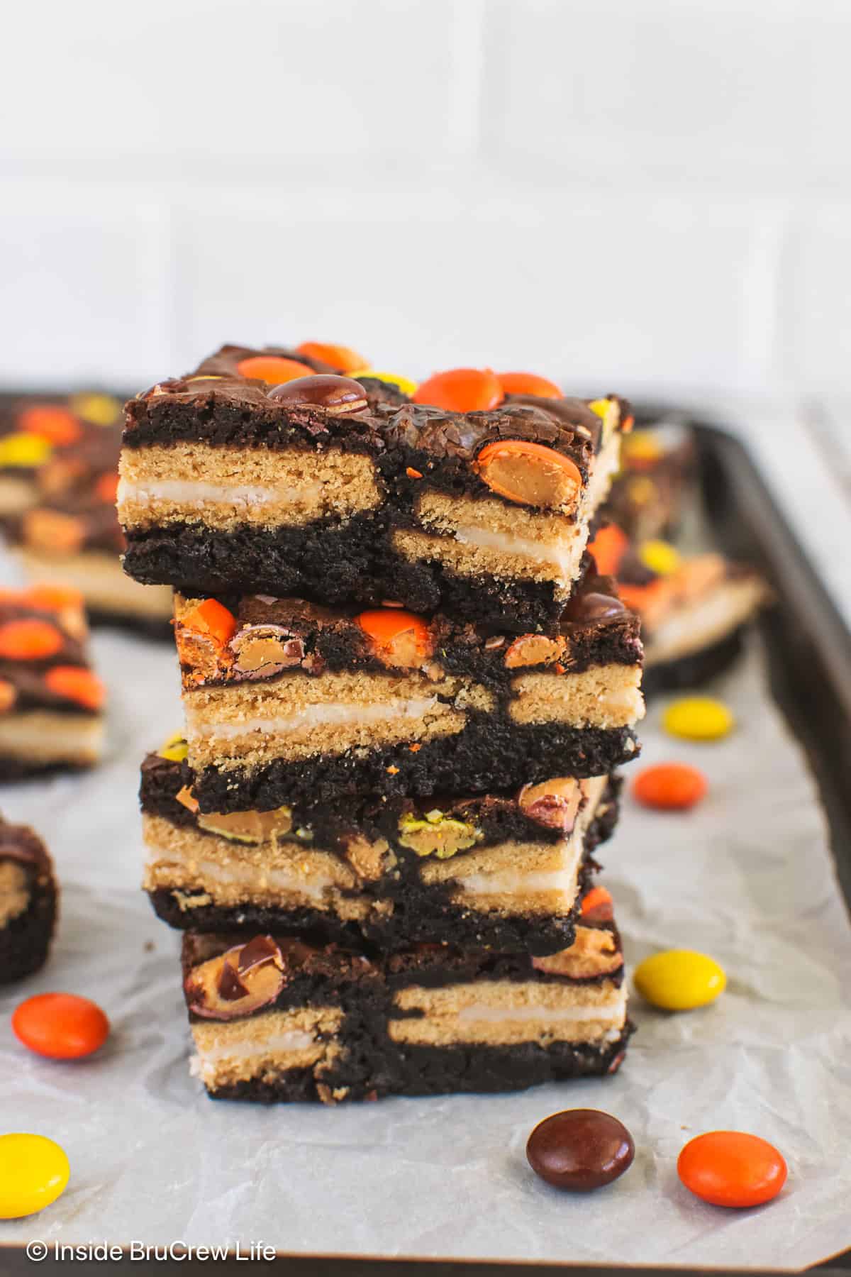 A stack of Reese's pieces brownies stuffed with Golden Oreos.