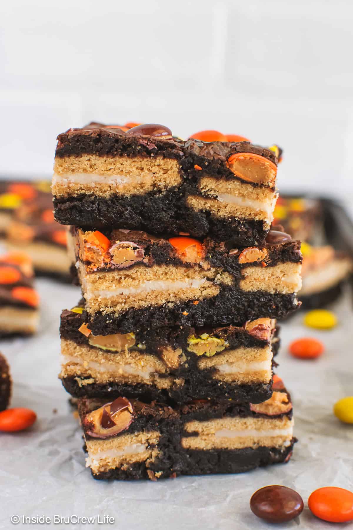 Four Reese's Pieces brownies stuffed with Golden Oreos on a pan.