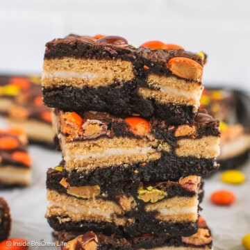 A stack of Reese's pieces brownies stuffed with Golden Oreos.
