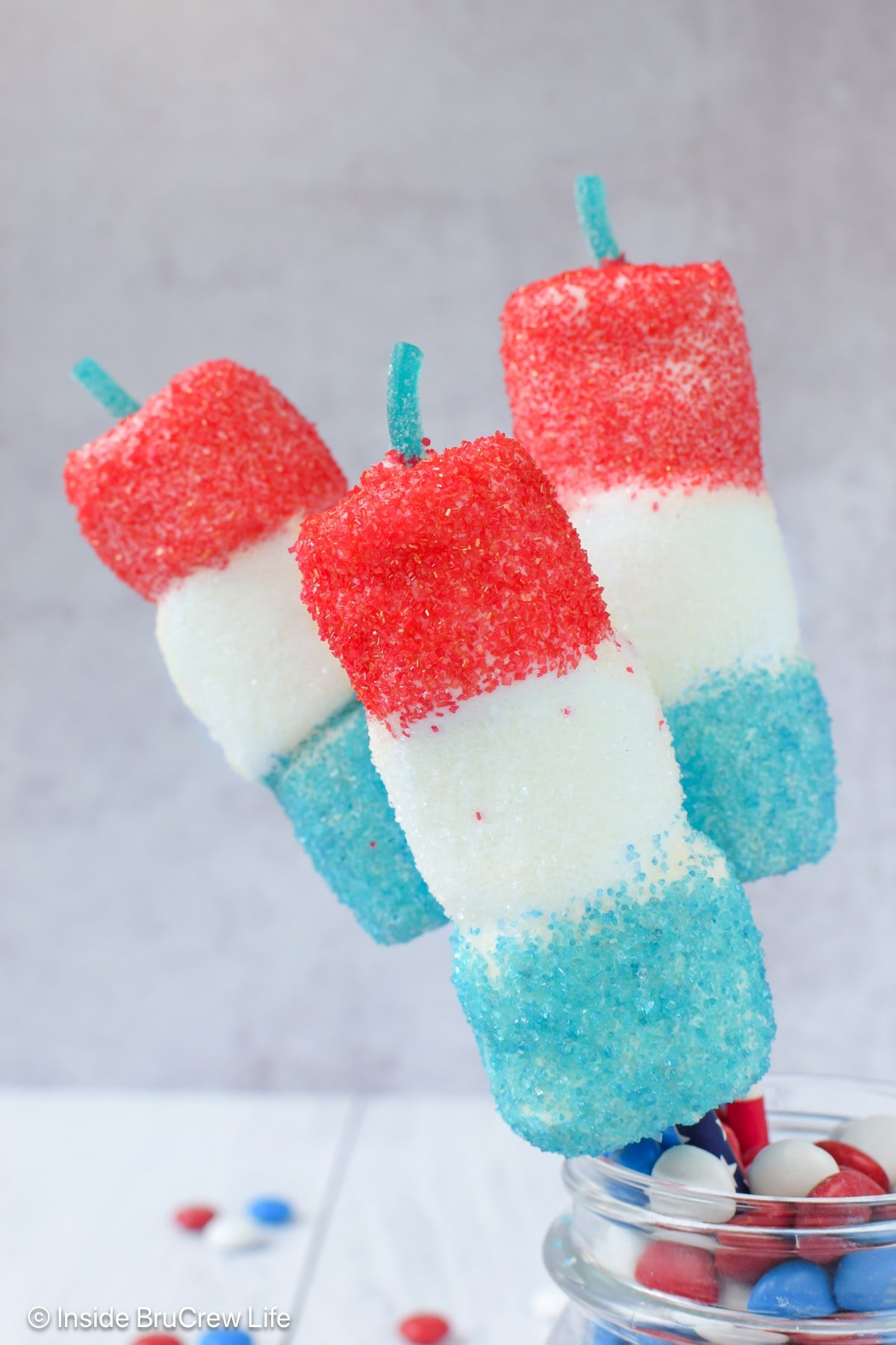 Three red white and blue marshmallow pops.