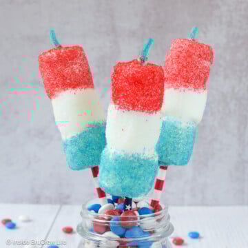 A jar of chocolate candies with three 4th of July marshmallow pops stuck in it.