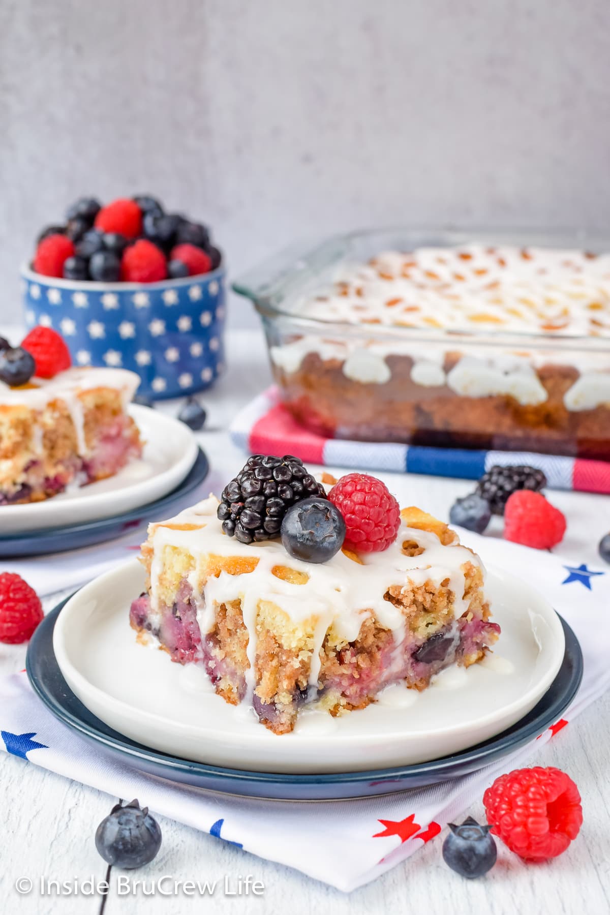 A slice of coffee cake topped with berries on a white plate.