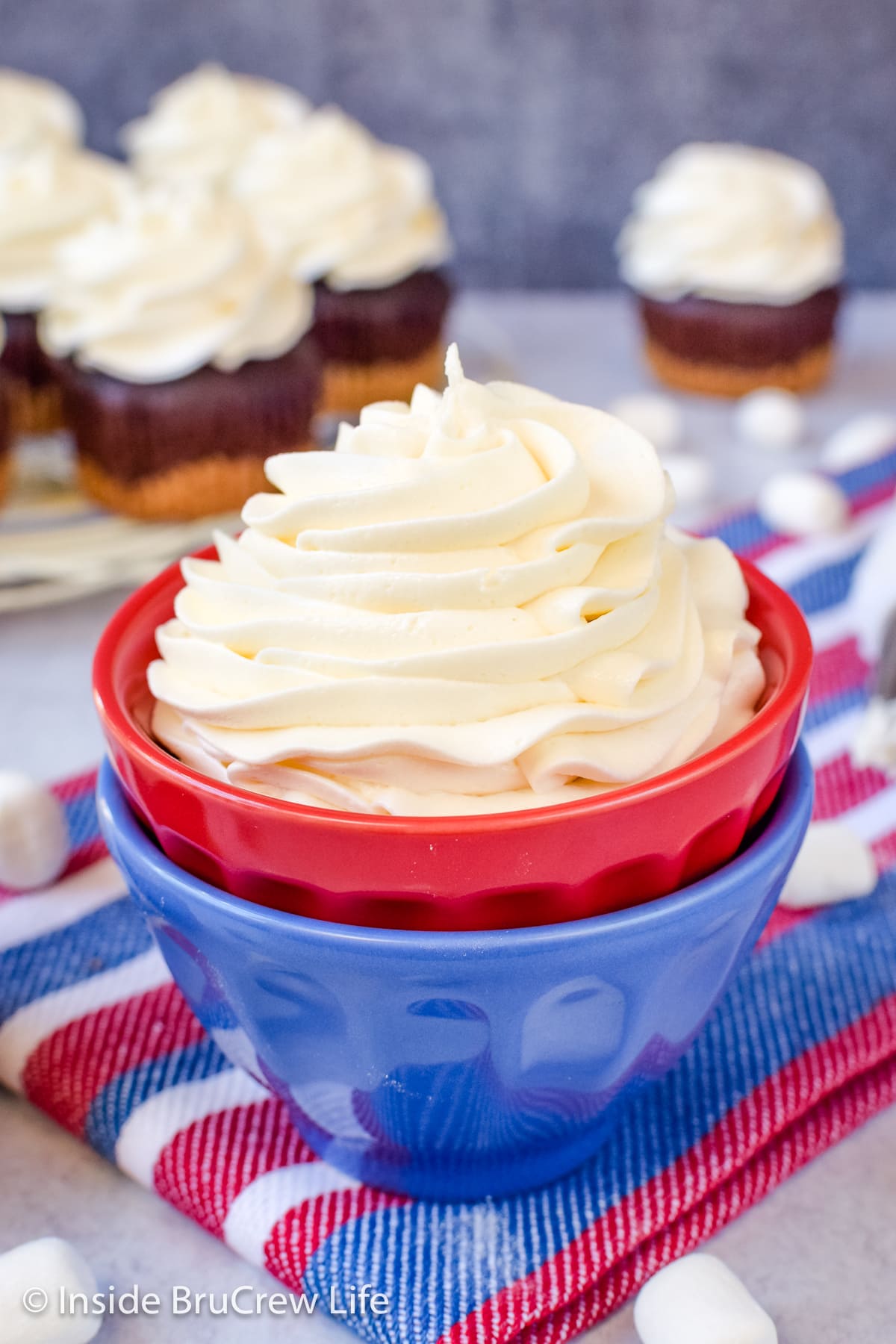 A swirl of buttercream in a red and blue bowl.