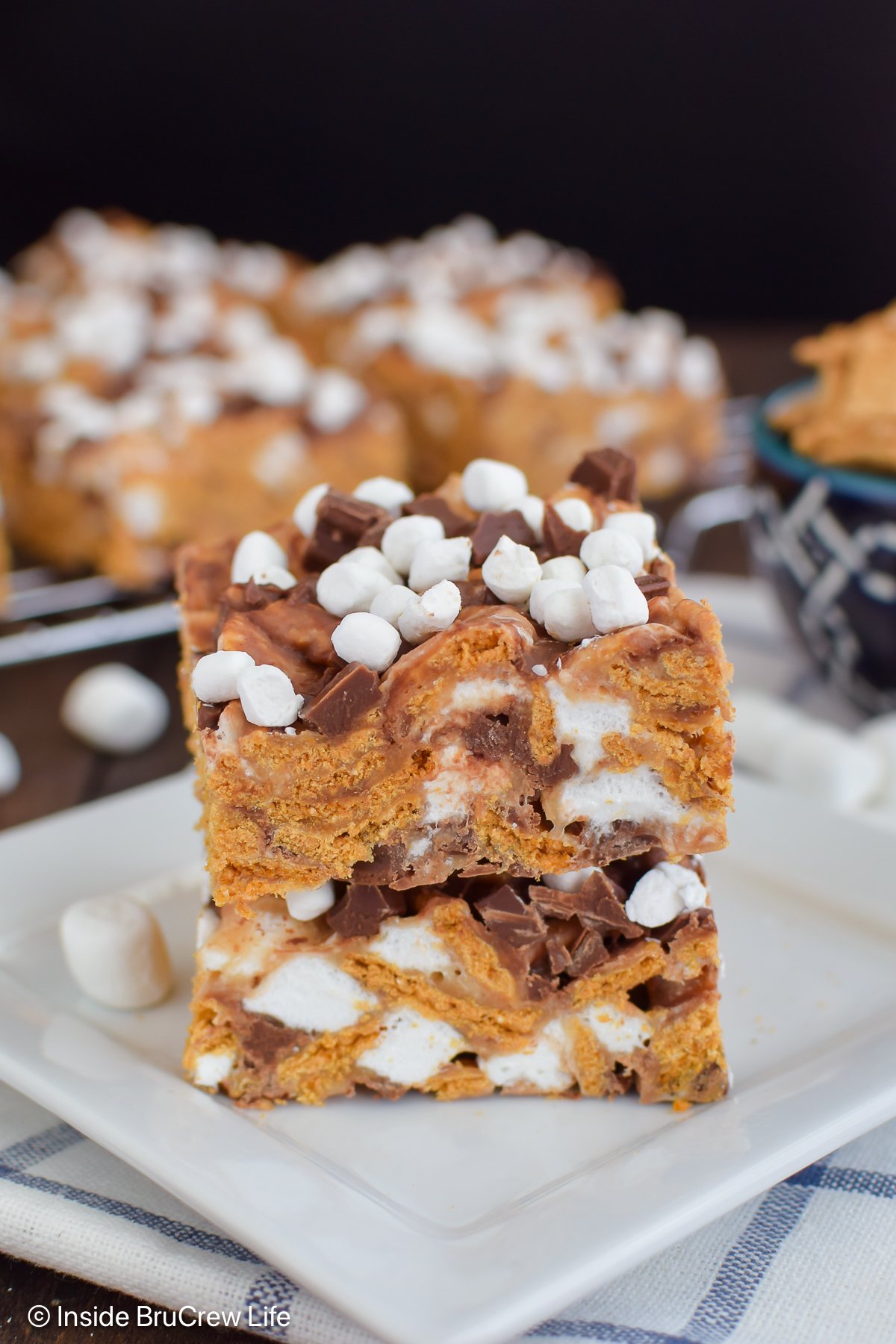 Two s'mores bars stacked on a white plate.