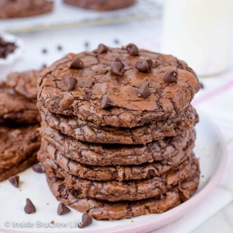 A stack of six chewy brownie cookies on a white plate.