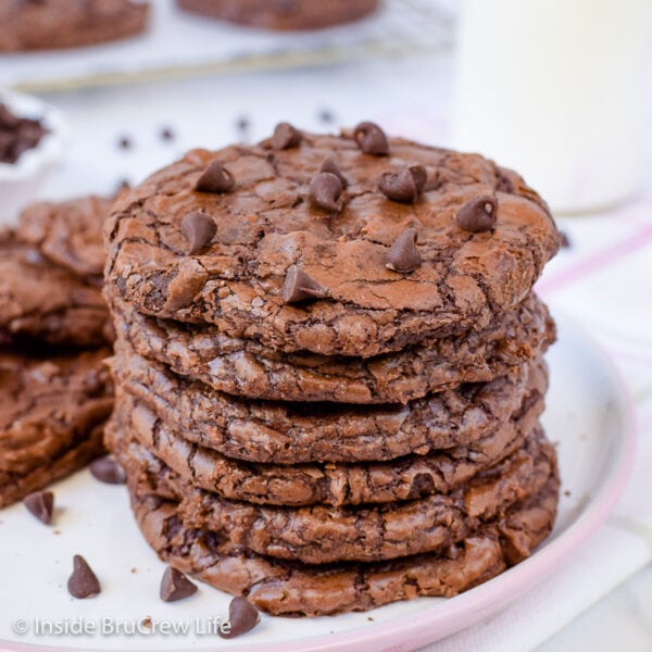 A stack of six chewy brownie cookies on a white plate.
