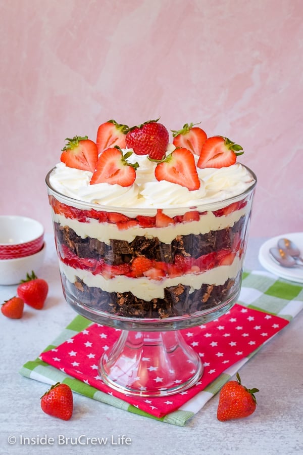 Easy No Bake napolilainen juustokakku Trifle - kerroksittain tuoreita marjoja, ei paista juustokakkua ja välipalakakkuja luo näyttävän mutta helpon jälkiruoan. Täydellinen resepti kuumille kesäpäiville! #caketrifle #nobakedessert #napolilainen #chocolate #strawberry #nobakecheesecake