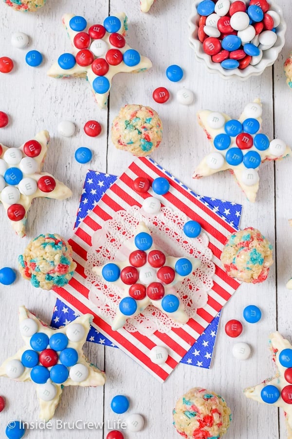 A white board with rice krispie treat stars topped with red white and blue m&m's on it