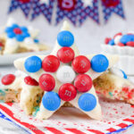A star shaped rice krispie treat decorated with red white and blue M&M's standing up.
