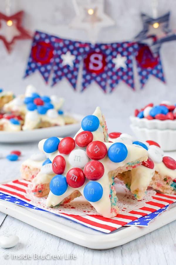 Rice krispie treat stars decorated with red white and blue M&M candies on a white board