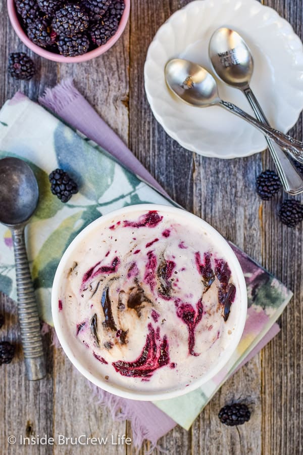 Overhead picture of a new container of blackberry fudge ice cream on a wood board.