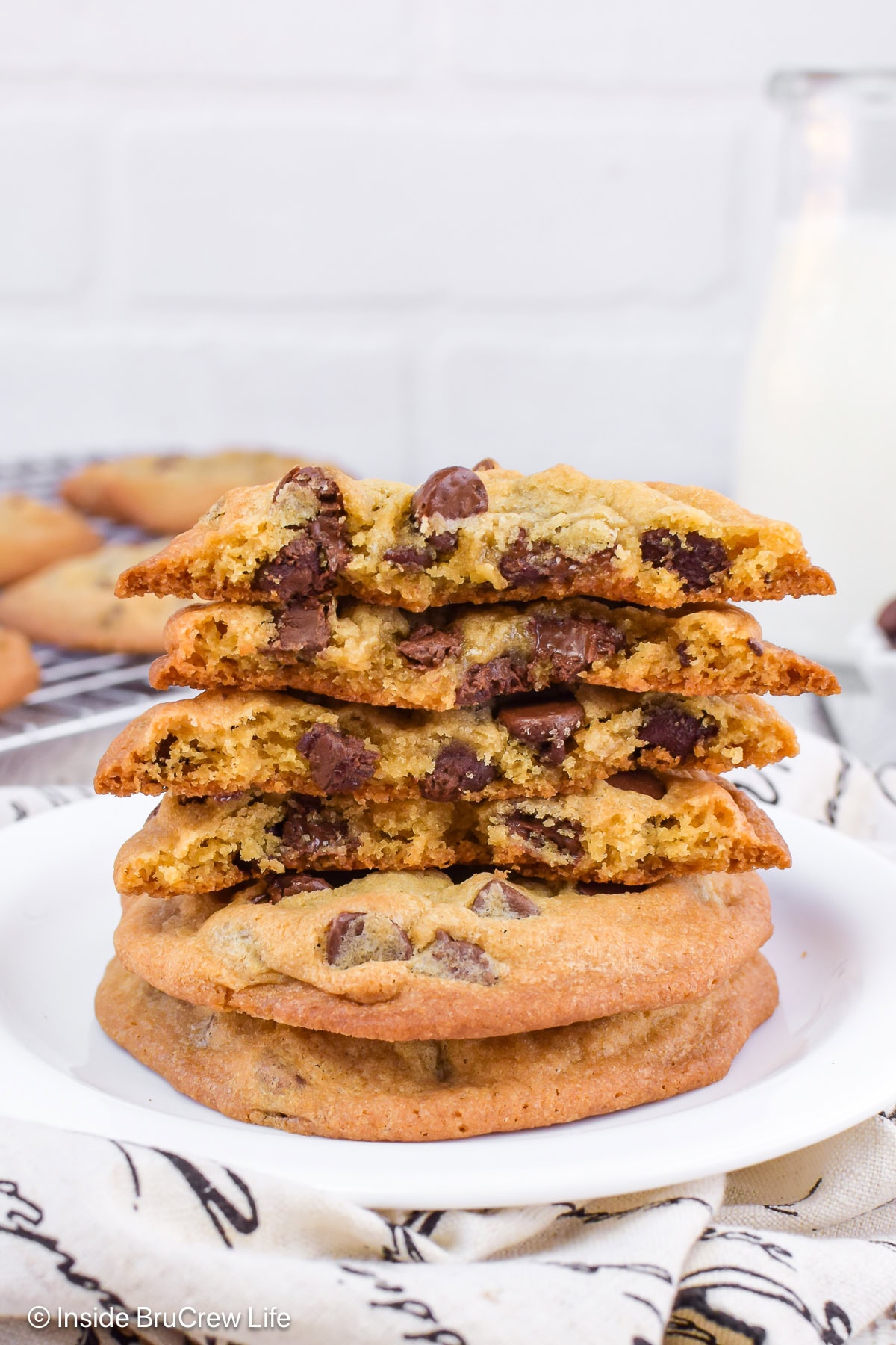 A stack of warm chocolate chip cookies broken in half.