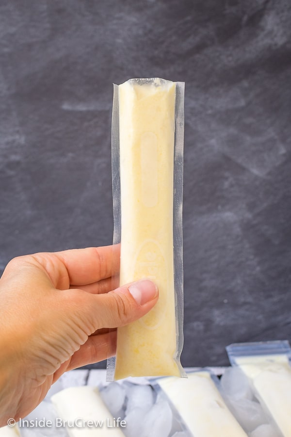 Easy Dole Whip Popsicles - keep a batch of these creamy homemade popsicles in your freezer for hot days. Great recipe that tastes like the popular Disney snack. #copycat #disney #dolewhip #popsicles #summerdessert #summerfun #summervibes #pineapple