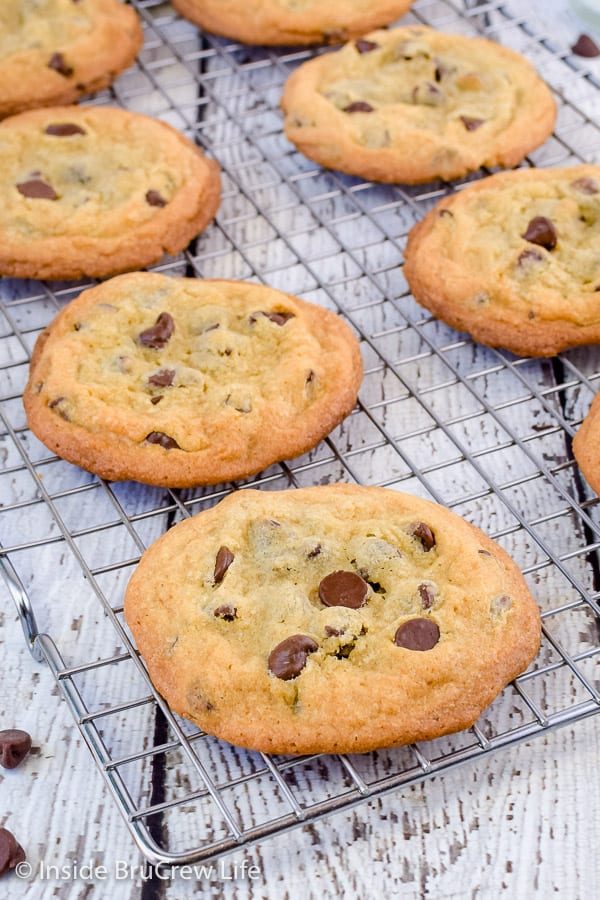 A wire rack with crisp and chewy chocolate chip cookies on it.