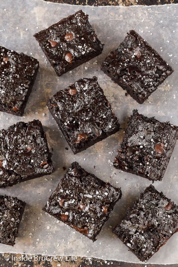 Overhead picture of 8 chocolate zucchini brownies on parchment paper