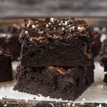 Two chocolate zucchini brownies stacked on top of each other and sprinkled with sea salt