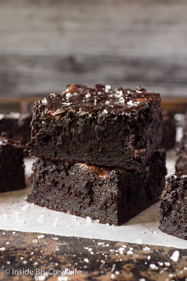 Two chocolate zucchini brownies stack on top of each other and sprinkled with sea salt