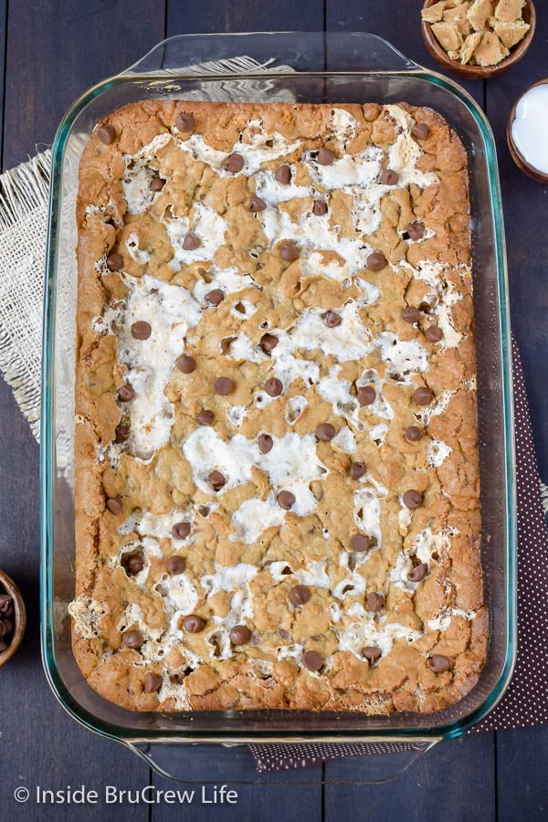 Overhead picture of a pan of s'mores bars on a dark board.