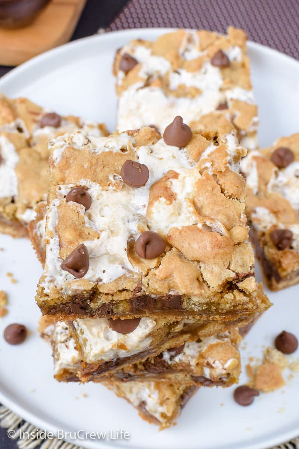 A white plate with squares of s'mores bars stacked on it.