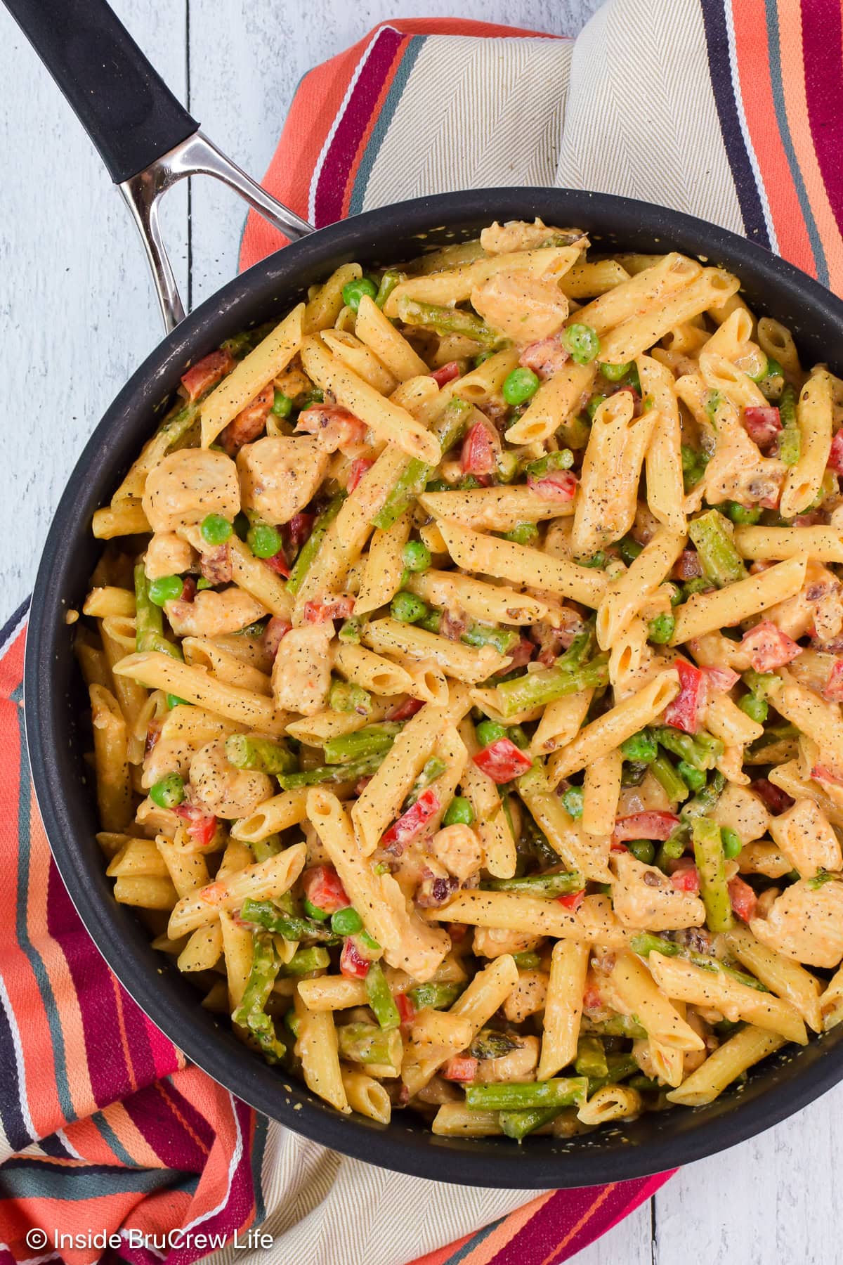 A black skillet filled with chicken and noodles in a spicy chipotle cream sauce.