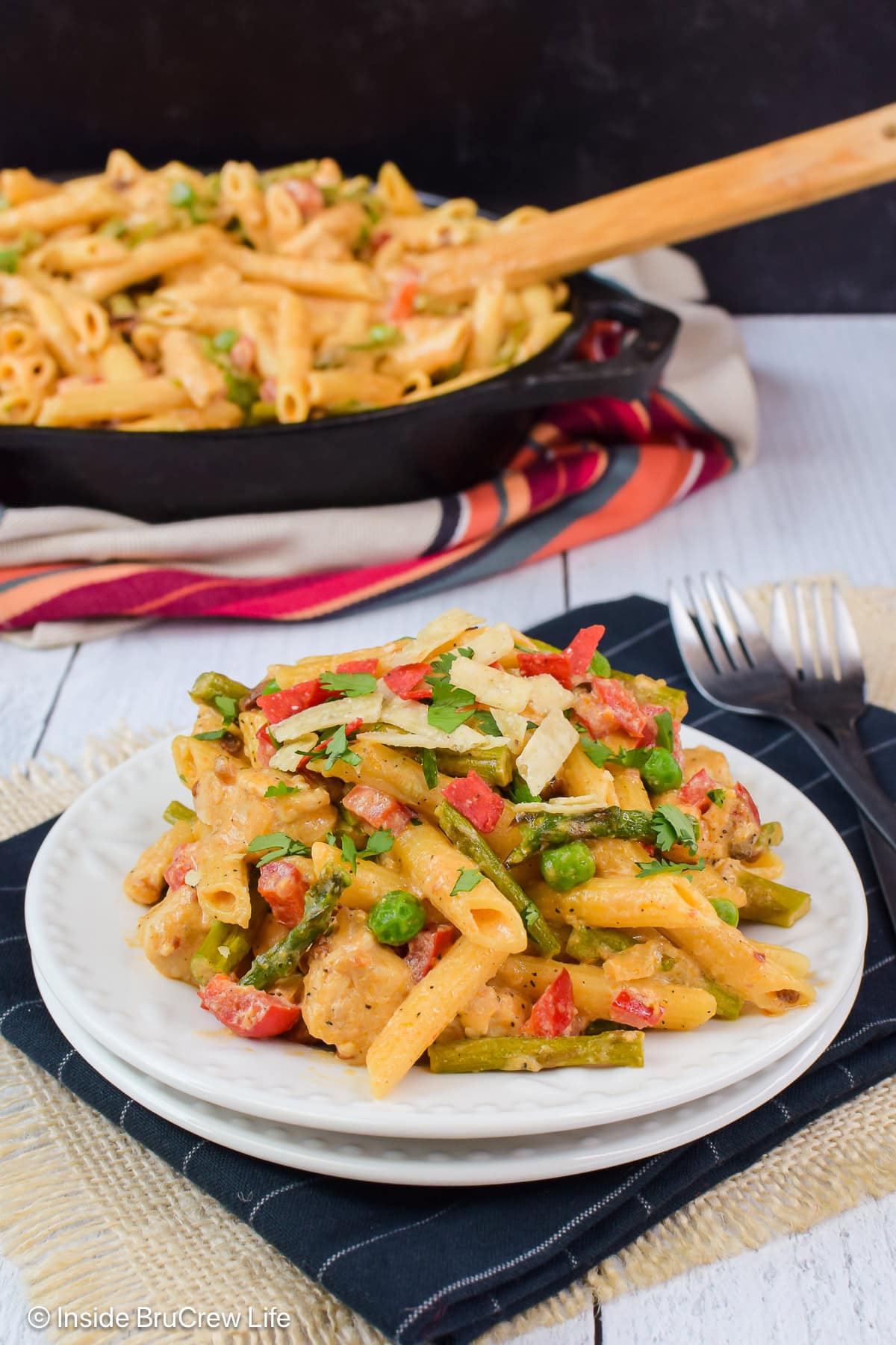 A plate of spicy pasta on a black towel.