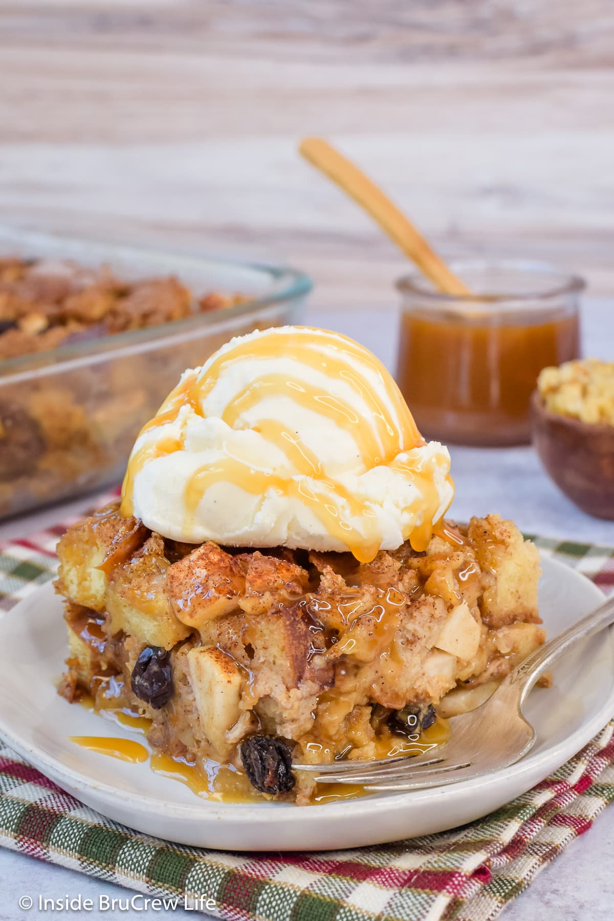 Apple bread casserole topped with ice cream and caramel.
