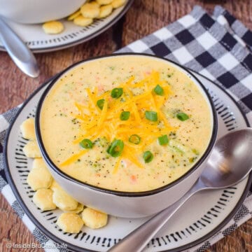 Two bowls of cheese soup loaded with broccoli chunks.