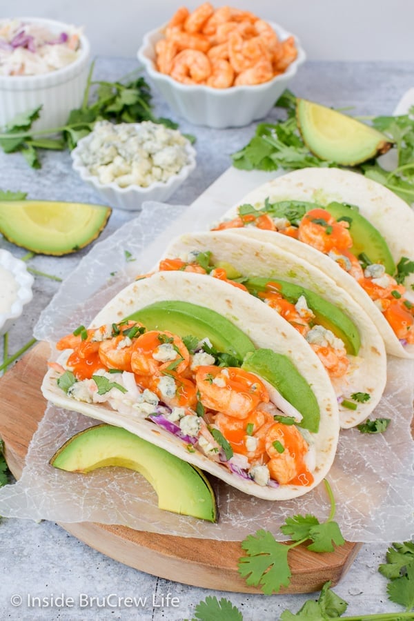 Easy Buffalo Shrimp Tacos - these easy shrimp tacos are loaded with toppings and drizzled with wing sauce. Great recipe to make on busy nights! #tacos #buffaloshrimp #shrimptacos #tacotuesday